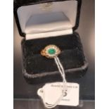 A Sheffield 9ct yellow gold ring set with a single green spinel surrounded by white spinel