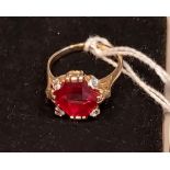 A 14ct yellow gold ring set with a large cut single ruby and four white spinel stones. [Ring size R]