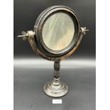 A 19th century convex table top mirror on a turned support and cast metal base.