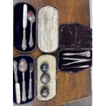 A boxed silver three piece flatware set and one other, three silver tops for perfume bottles and