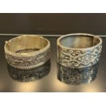 A Chinese Silver marked ornate bangle, together with a Birmingham silver bangle. [88.25grams]