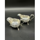 A Lot of two Sheffield silver milk jugs supported on three legs. [Both as found in areas] [443.