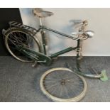 A Vintage Raleigh green painted bike. Has original pump and front light attached.