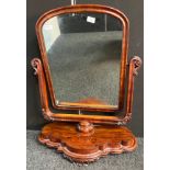 Antique walnut mirror, the shaped moulded swing frame above a carved shaped base [86x66x29cm]