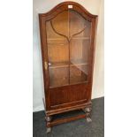 Wooden display cabinet, the arched moulded cornice above a single glazed door opening to shelves,