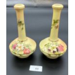 A Pair of blush ivory and hand painted bottle neck vases produced by Royal Worcester. [18cm high]