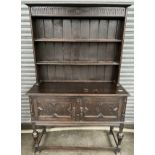 Antique oak dresser, the moulded cornice above two enclosed shelves, the base with two moulded