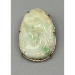 A Foreign marked gold brooch/ pendant fitted with a Chinese carved Jade ingot. [4x3cm] [We will