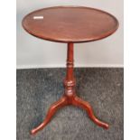 Mahogany tripod table, the circular top with moulded edge raised on turned tapered column and