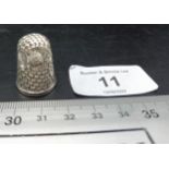 A thimble with owl embossed decoration