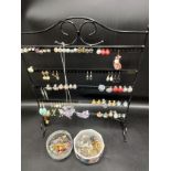 Quantity of earrings on stand together with badges etc.