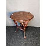 Antique cast iron table, the circular wooden top above a pierced cast iron base [ 72x61cm]