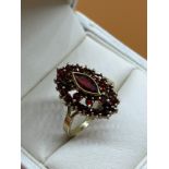 14ct yellow gold ladies ring set with a cluster of garnet stones set with a large garnet to the
