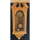Light oak cased wall clock, Ornate brass style face and matching pendulum. Comes with key. [Will not