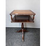 Mahogany leather top table with undertier, raised on outswept legs ending in brass cap feet (