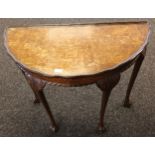 Burr Walnut half-moon table, Supported on four ball and claw feet.