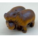 Japanese hand carved netsuke sculpture of a pair of hippos, both have black bead eyes and signed