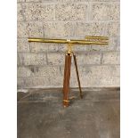 Large brass telescope on wooden support stand .