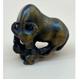 Japanese hand carved netsuke sculpture of an Ox standing on a monkey. Signed. [4.5cm high]