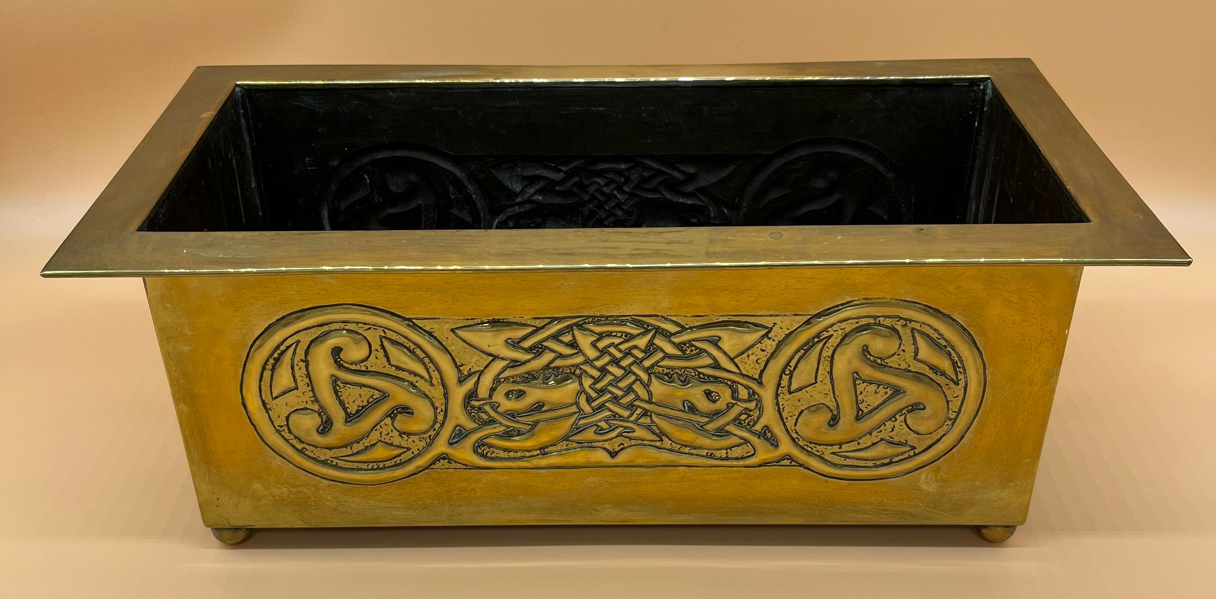 Arts and Crafts brass worked planter. detailed with Celtic panels. [Missing handle] [19x49x24cm]