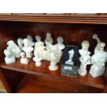 Shelf of small Greek and history style busts.