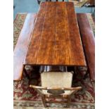 Solid wood refectory table, the rectangular top raised on two balusters and trestle bases, joined by
