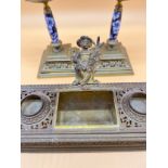 19th century brass ornate double ink well stand designed with cherub figure lid to centre.