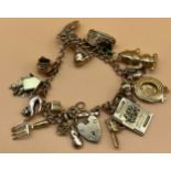 9ct yellow gold charm bracelet containing various 9ct gold charms includes 18ct gold hat charm. [