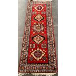 Red and blue ground woven Indian ornate rug. [261x92cm]