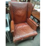 Antique leather gulwing chair with caster feet .