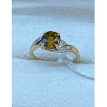 10ct yellow gold brown/yellow tanzanite stone off set by diamond shoulders. [Ring size O] [2.