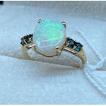 14Ct yellow gold ring set with a large single white opal off set by two green tourmaline stones to