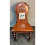 19th century hall chair, the shaped back with carved detail and fitted with a Minton's tile to the