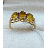 10ct yellow gold ladies ring set with three large orange tourmaline stones of set by diamond cluster
