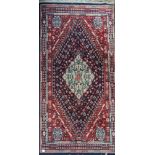 Antique ornate rug in a red and tone blue