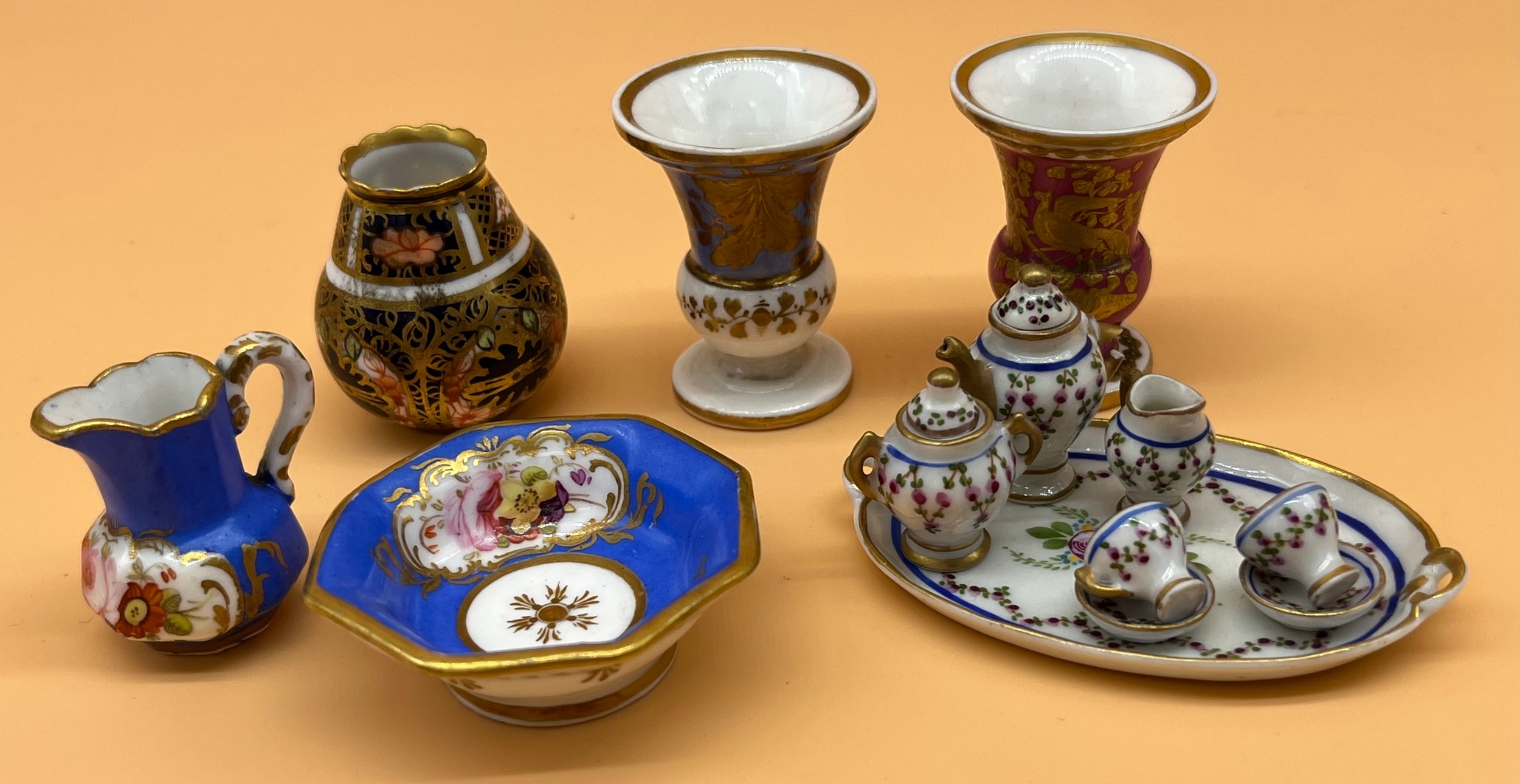 Collection of collectable miniature porcelain items to include Dolls tea for two service, Urn vases,