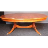 Reproduction table, the oval top raised on two turned columns and three outswept legs ending in