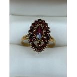 14ct yellow gold ladies ring set with a cluster of garnet stones set with a large garnet to the