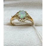 9ct yellow gold ladies ring set with a single opal stone off set by two small diamonds. [1.
