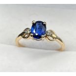 10ct yellow gold ring set with a single blue spinel stone off set by diamonds. [Three diamonds to