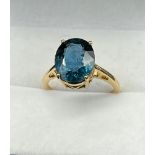 10ct yellow gold ring set with a large oval cut blue spinel stone. [Ring size P] [4.11Grams]