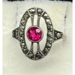 Gold and silver art deco ring set with a single round cut ruby surrounded by marcasite stones. [