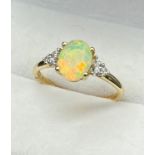 10ct yellow gold ladies ring set with an Oval cut opalescent style centre stone off set by three