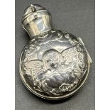 London silver ornate encased perfume bottle. Silver cover is detailed with foliage trim with