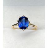 10ct yellow gold ring set with a large oval cut blue topaz stone. [Ring size P] [2.60Grams]