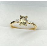 10ct yellow gold ladies ring set with a single emerald cut pale green topaz stone of set by