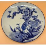 A Large Antique Chinese blue and white wall charger depicting hand painted bird perched on a tree.