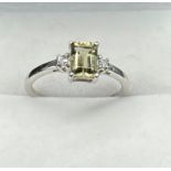 10ct White gold ladies ring set with an emerald cut pale green spinel stone off set by white