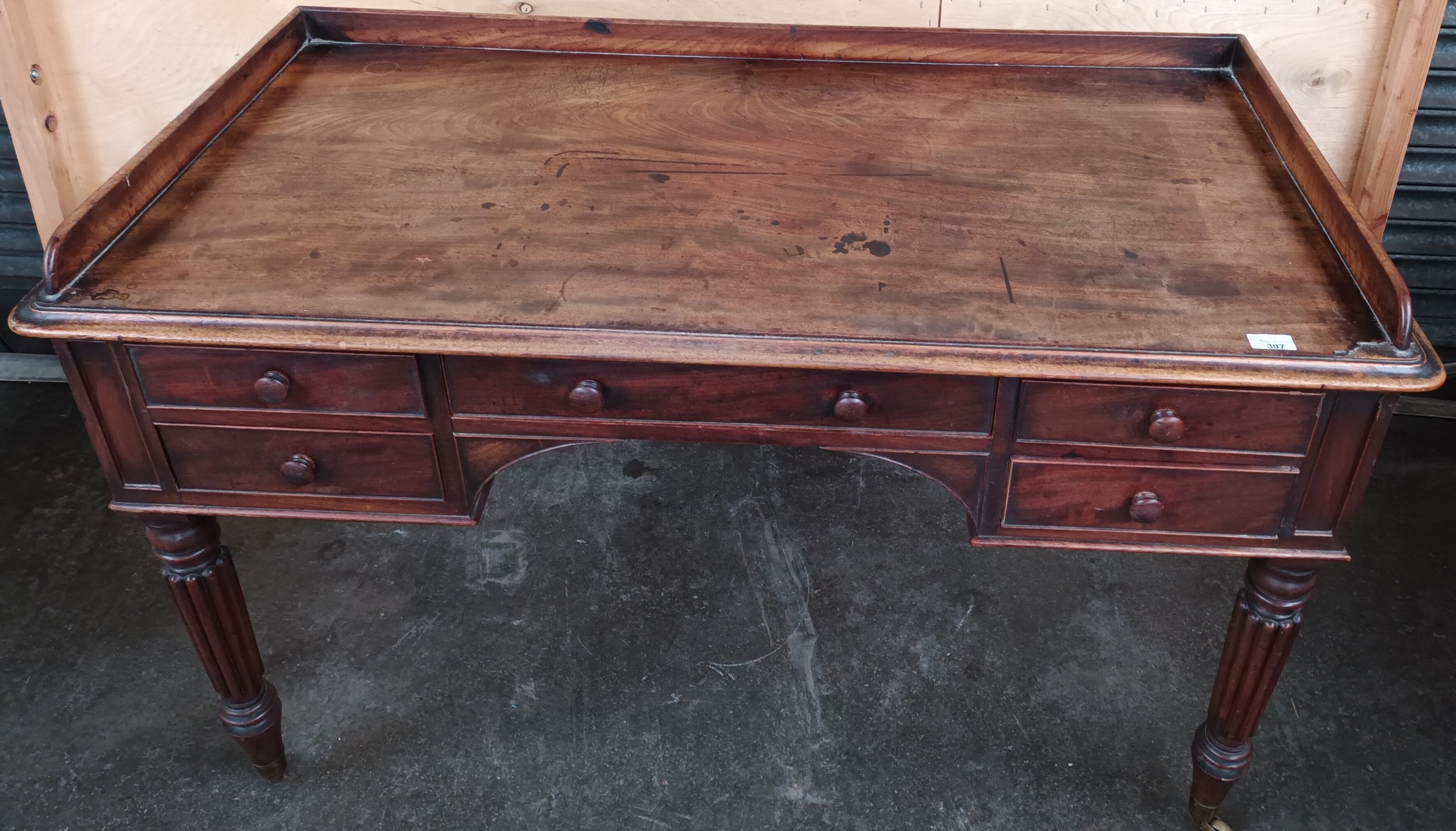 19th century desk, the gallery top above a writing surface and an arrangement of drawers, raised