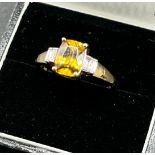 14ct yellow gold ladies ring set with a large yellow tourmaline stone off set by emerald cut diamond